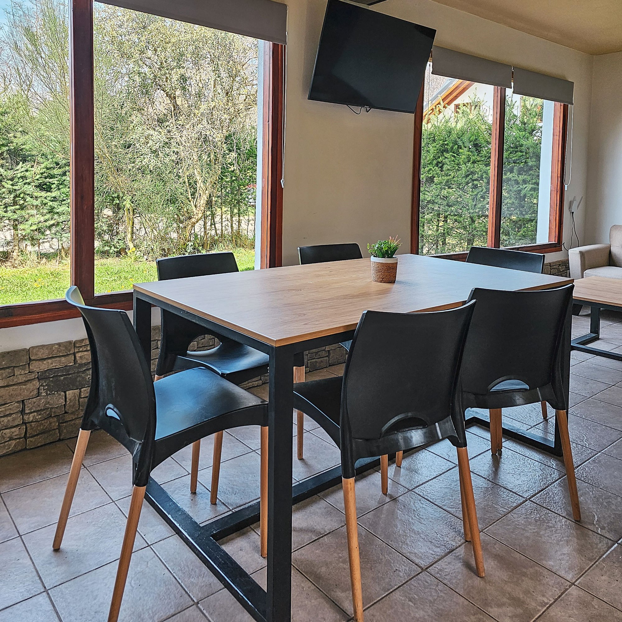 Comedor con ventanales al jardín — Casa Aicu